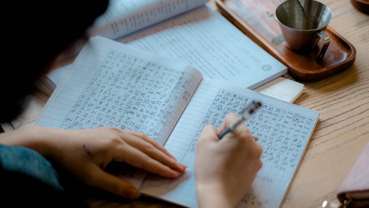 Student practising Japanese characters in a language class